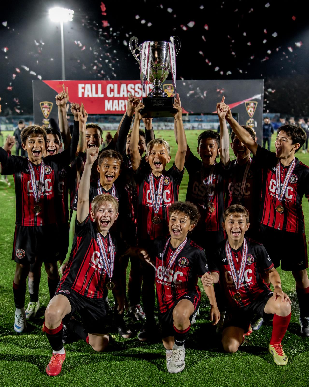 Youth team celebrating with a tournament trophy